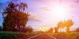 Uno sguardo oltre il finestrino del treno: una collina e la casa dei sogni binario