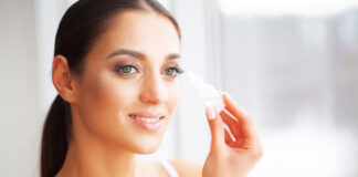 Tremolio all’occhio: origini e consigli per risolvere il problema Health and Beauty. Eye Care. Beautiful Young Woman Holding Drops For Eyes. Good Vision. Happy Girl with Fresh Look