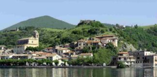 Un borgo sospeso nel tempo: acque cristalline, storia millenaria e una vista sul lago che lascia senza fiato Situato sulla sponda settentrionale del lago, il paese si erge su una rupe di lava leucitica a 173 metri sul livello del mare,